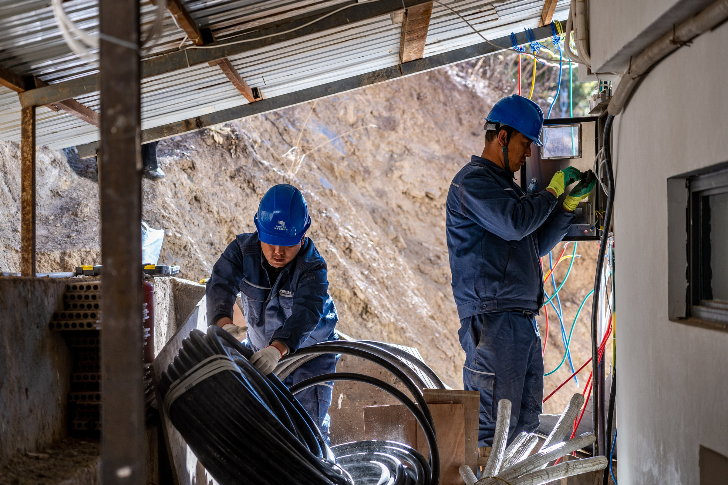 Wangden inspects power lines for a hotel with his colleague in Yubeng Village, Deqen County, Yunnan Province